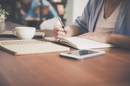 grátis Mulher Escrevendo Em Um Notebook Ao Lado Da Xícara De Chá E Do Computador Tablet Foto profissional